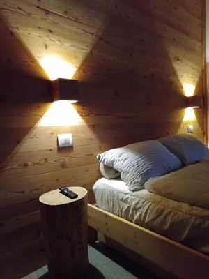 a bedroom with a bed in a wooden wall at Loft 69 - Green Relax in Cles