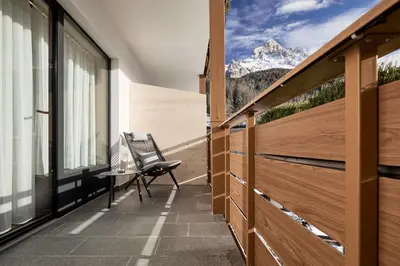 a balcony with a chair and a view of a mountain at Hotel DAS ROYAL in Obereggen in Obereggen