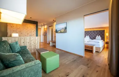 a hotel room with a bed and a couch at Hotel DAS ROYAL in Obereggen in Obereggen