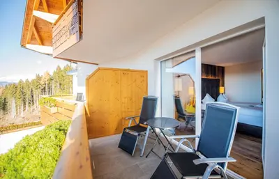 a room with a view of a bedroom and a bed at Hotel DAS ROYAL in Obereggen in Obereggen