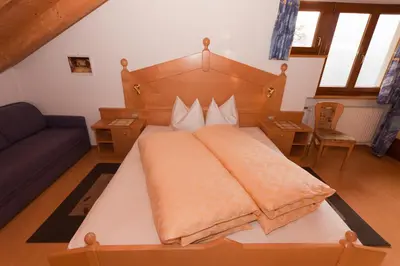a bedroom with a large bed with a wooden headboard at Haus Sabine in Laion