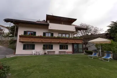 a house with chairs and an umbrella in the yard at Haus Sabine in Laion