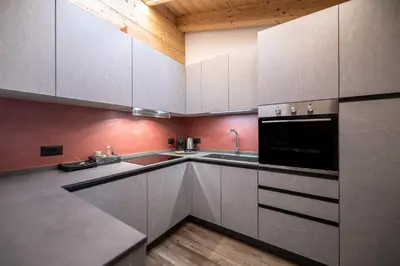 a kitchen with white cabinets and a sink at - Punta Penia - Canazei center app in Canazei