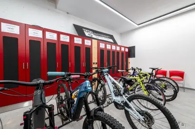 a row of bikes parked in a room with red lockers at - Punta Penia - Canazei center app in Canazei