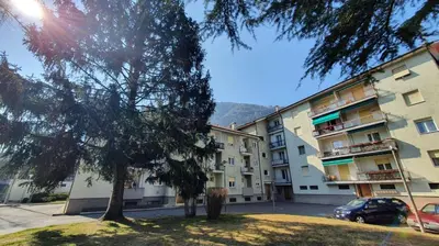 an apartment building with a tree in front of it at Stay City in MeranO with Bio Sauna in Merano