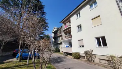 a white building with a blue car parked next to it at Stay City in MeranO with Bio Sauna in Merano