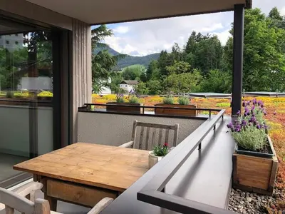a balcony with a wooden table and flowers on it at Apartment Malfi in Fiè