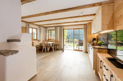 a kitchen with wooden ceilings and a dining room at Bäckerhof in Tesido