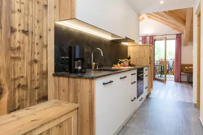 a kitchen with wooden walls and a counter with a sink at Bäckerhof in Tesido