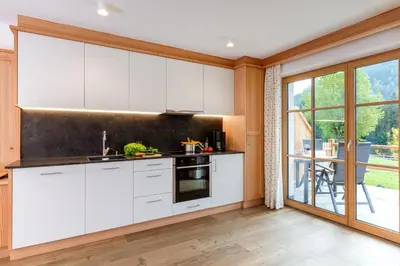 a kitchen with white cabinets and a large window at Bäckerhof in Tesido
