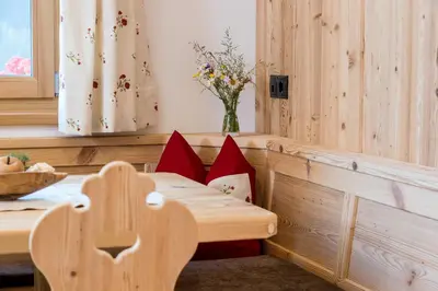 a room with a table and a bench with pillows at Bäckerhof in Tesido