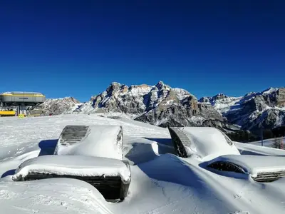 two snowcovered chairs sitting on top of a snow covered mountain at Ciasa Gabriel in Colfosco