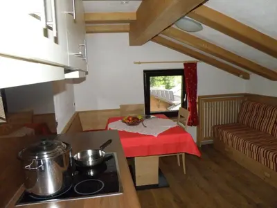 a kitchen with a table and a couch in a room at Ciasa Gabriel in Colfosco