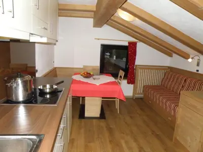 a kitchen with a table and a couch in a room at Ciasa Gabriel in Colfosco