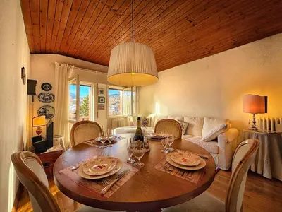 a dining room with a table with a christmas tree at Attico con vista sulle Tofane in Maion