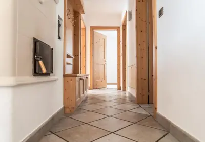 a hallway with a tiled floor and a television at Apartment Misalt in Castelrotto