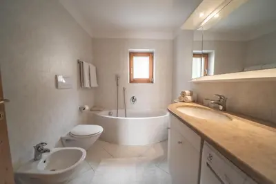 a bathroom with a tub and a toilet and a sink at Apartment Misalt in Castelrotto