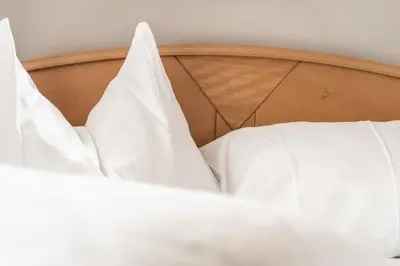 a close up of a bed with white sheets at Apartment Misalt in Castelrotto