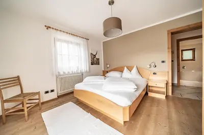 a bedroom with a bed and a chair in it at Apartment Misalt in Castelrotto