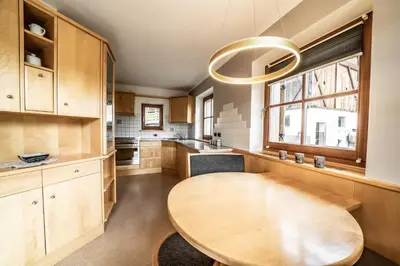 a kitchen with a wooden table and a large window at Apartment Misalt in Castelrotto