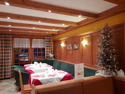 a dining room with a christmas tree and a table at B&B Chalet Brigitte Hike & Bike in Arabba
