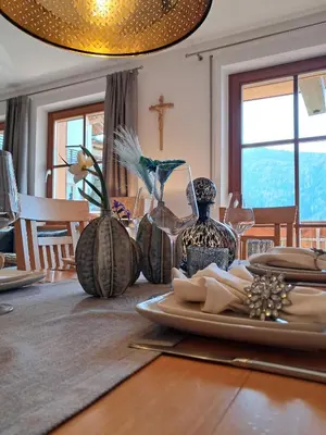 a dining room table with plates and vases on it at Unterkirnhof in Schenna