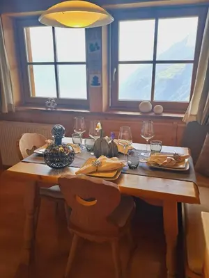 a wooden table with chairs and wine glasses on it at Unterkirnhof in Schenna