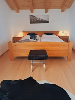 a bedroom with a large bed and a chair at Unterkirnhof in Schenna