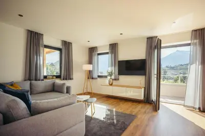 a living room with a couch and a tv at Suite Mais in Merano