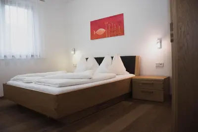 a bedroom with a large bed with white pillows at Appartment Waldrand in Castelrotto