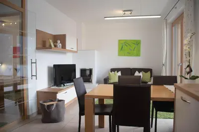 a kitchen and dining room with a table and chairs at Appartment Waldrand in Castelrotto