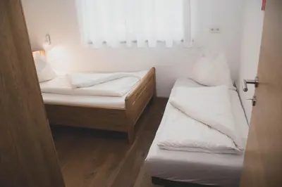 a small room with two beds and a window at Appartment Waldrand in Castelrotto