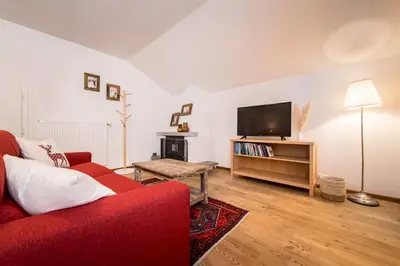 a living room with a red couch and a flat screen tv at Am Schloss Guest House in Brunico