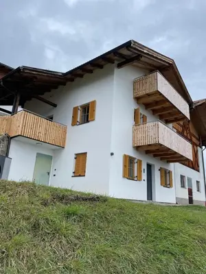 a white building with wooden balconies on it at Ferienhaus Gann - Greit in Villandro