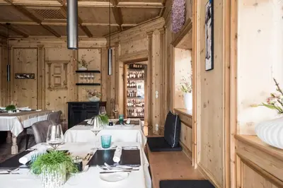 a dining room with tables with white tablecloths at Hotel Chalet Das Alpenschlössel in Saltusio