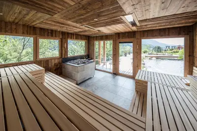 a large room with two benches and a fireplace at Hotel Chalet Das Alpenschlössel in Saltusio