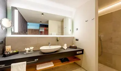 a bathroom with a sink and a large mirror at Hotel Chalet Das Alpenschlössel in Saltusio
