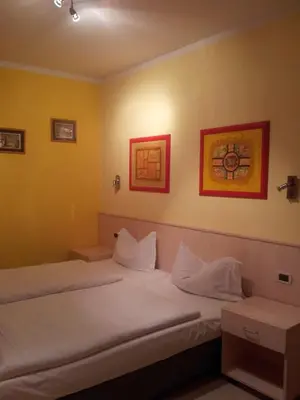 two beds in a room with yellow walls at Chalet Helen in Arabba