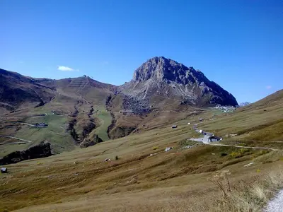 a mountain with a road in the middle of a field at Chalet Helen in Arabba