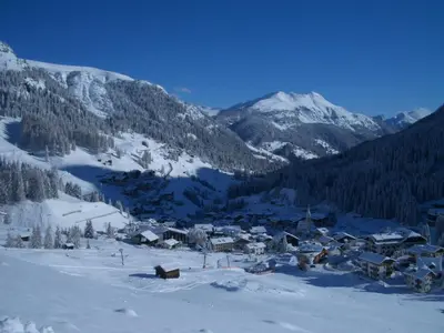 a village in the snow with mountains in the background at Chalet Helen in Arabba
