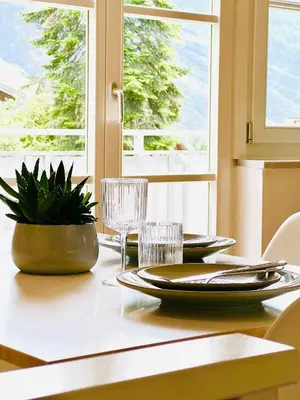 a dining room table with plates and glasses and a window at Villa Maria in Rablà