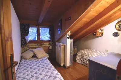 a bedroom with two beds in a room at Cozy attic in the center of San Vito in San Vito di Cadore
