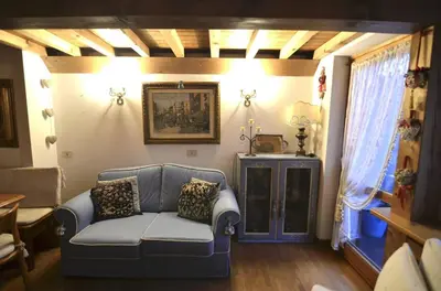 a living room with a blue couch and a window at Cozy attic in the center of San Vito in San Vito di Cadore