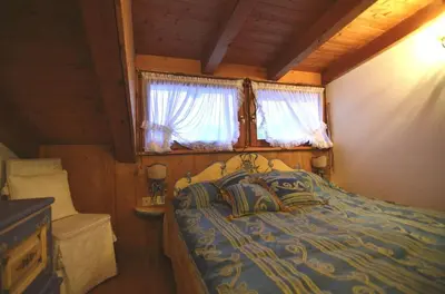 a bedroom with a bed in a cabin with a window at Cozy attic in the center of San Vito in San Vito di Cadore