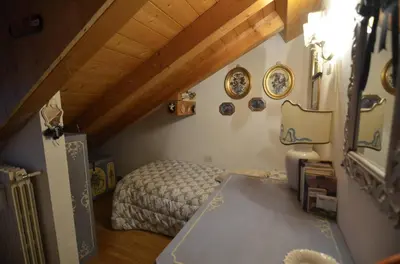 a small bedroom with a bed in a attic at Cozy attic in the center of San Vito in San Vito di Cadore