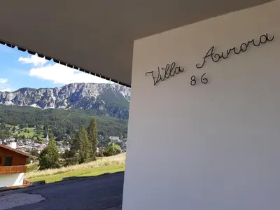 a sign for a house with mountains in the background at Villa Aurora in Pocol