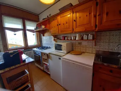 a kitchen with wooden cabinets and a white refrigerator at Villa Aurora in Pocol