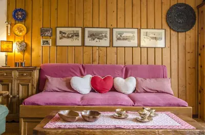 a purple couch with three heart pillows on it at Villa Aurora in Pocol