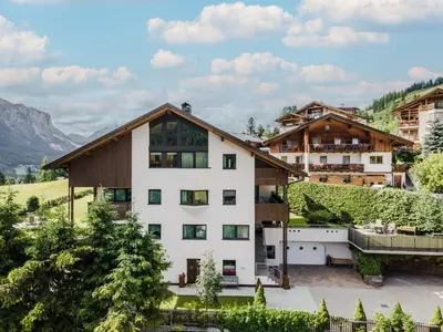 two chairs and a table on a grassy hill at Apartment Ciasa Laoi in San Cassiano