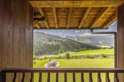a bedroom with a bed with a red comforter at Apartment Ciasa Laoi in San Cassiano